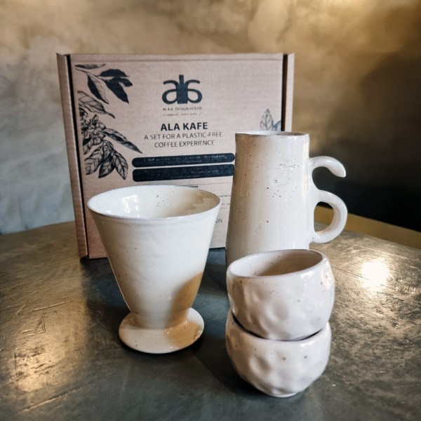Ala Kafé Coffee Set with ceramic filter cone, jug, and two cups, placed in front of a natural cardboard box — handcrafted, sustainable, and plastic-free.
